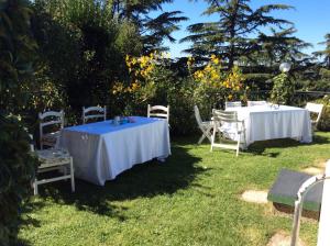 dwa stoły i krzesła siedzące w trawie w obiekcie Villa Covaccioli Schimperna w mieście Formello
