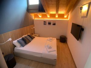 - une petite chambre avec un lit et une télévision dans l'établissement Appartamenti Passuello Padola - Blue, à Padola