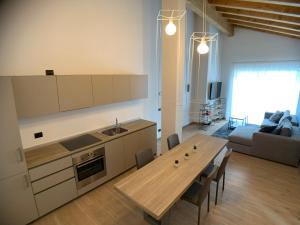uma cozinha e sala de estar com uma mesa e um sofá em Appartamenti Passuello Padola - Blue em Padola