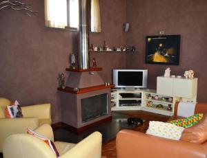 een woonkamer met een open haard en een televisie bij B&B Olania in Castellammare di Stabia