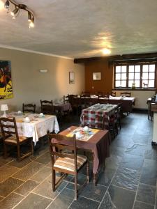 ein Restaurant mit Tischen und Stühlen in einem Raum in der Unterkunft Hostellerie Hérock in Herock