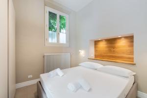 una camera con due letti bianchi e una finestra di Borgo Pinti Garden Suite a Firenze