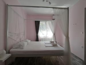 lustro odbijające łóżko w pokoju z oknem w obiekcie "ΙωΚαρ" w mieście Nafpaktos