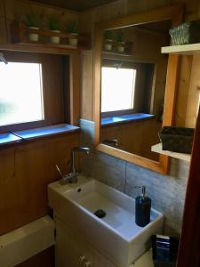 a small bathroom with a sink and two windows at La bigoudène in Wambrechies