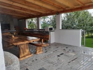 a large wooden table on a patio with a microwave at Casa da Emanuela in Drežnik Grad