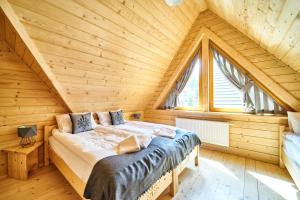 - une chambre avec un lit dans une maison en bois dans l'établissement Osada nad potokiem, à Kościelisko