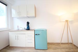 Moderne, helle 1 Zimmer-Wohnung in Citylage في باد أوراش: وجود ثلاجة زرقاء في مطبخ مع مصباح