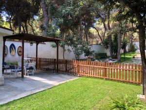 a wooden fence in a yard with a gazebo at Bungalow Fatamorgana in Pulsano