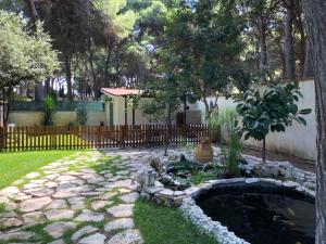 a garden with a pond in a yard with a fence at Bungalow Fatamorgana in Pulsano
