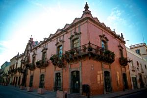 un gran edificio de ladrillo con un balcón en una calle en La Casa de la Marquesa, en Querétaro