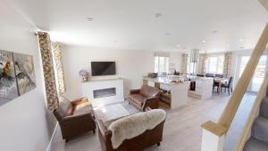a living room with a kitchen and a dining room at The Woodland Collection, 10 mins from beaches in Hayle