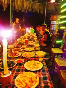 a long table with plates of food on it at Mường Trà Garden Homestay in Làng Cac
