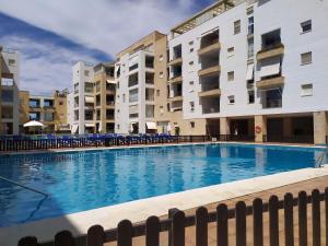 einem Pool vor zwei Apartmentgebäuden in der Unterkunft Primera linea de playa Punta del Moral El Espigon in Ayamonte