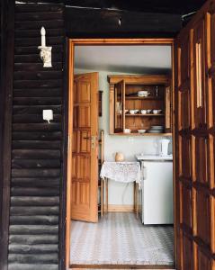 a kitchen with a wooden door and a kitchen counter at Hotel oraz domy - Kanu Club in Nowy Zyzdrój