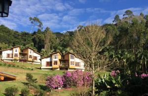 szereg domów na wzgórzu z drzewami w obiekcie Eco Pousada Quaresmeiras w mieście Domingos Martins