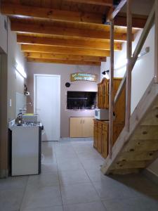 une grande cuisine avec des plafonds en bois et un escalier dans l'établissement La casa del Titi, à Tandil