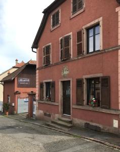 a red brick building with windows and a door at La bacchante in Saint-Hippolyte