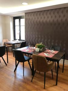 a dining room with a table and chairs and a wall at La bacchante in Saint-Hippolyte