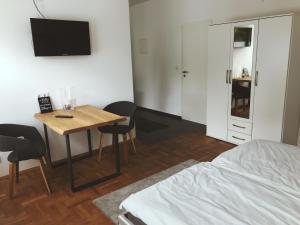 a room with a bed and a table and a tv at Robert Koch in Arnsberg