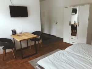 アルンスベルクにあるRobert Kochのベッド、テーブル、テレビが備わる客室です。