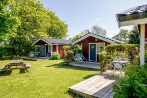 ein Cottage mit einem Picknicktisch und Stühlen im Hof in der Unterkunft B&B Olsegården in Tvååker