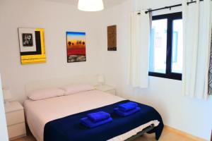 a bedroom with a bed with two blue towels on it at Casa Nemo Cotillo Mar in El Cotillo