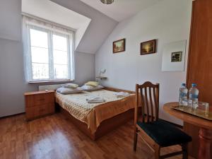 a bedroom with a bed and a table and a chair at Hotel TERESITA in Krakow