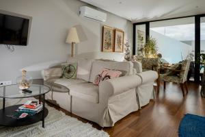 a living room with a couch and a table at Praia de Santos, Exclusive Villa, Açores in Ponta Delgada