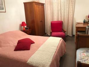 モリアニ・プラージュにあるRésidence Roi Theodoreのベッドルーム1室(赤いベッド1台、赤い椅子付)