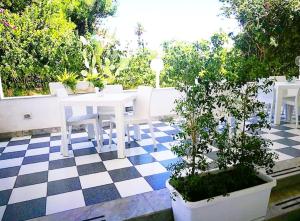 um pátio com uma mesa e cadeiras num piso em xadrez em Casa Lu Salentu em Torre Lapillo