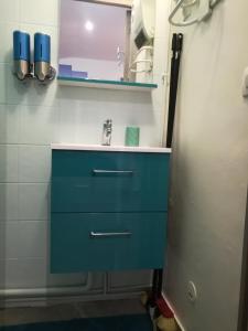 a bathroom with a blue sink and a mirror at Studio Le Palmier - Paris Gare du Nord en 15 min - in Deuil-la-Barre