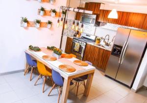 a kitchen with a table with chairs and a refrigerator at Boho Condominium and Unique Comfort in Tijuana in Tijuana