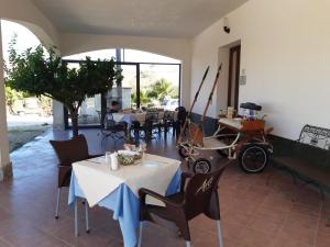 a dining room with tables and chairs and a carriage at Segesta Antichi Sapori in Calatafimi