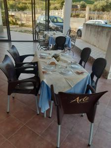 stół z krzesłami i stół z jedzeniem w obiekcie Segesta Antichi Sapori w mieście Calatafimi