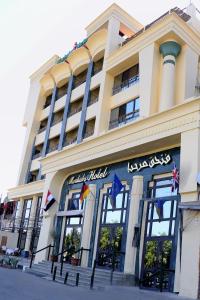 un grand bâtiment avec drapeaux devant lui dans l'établissement Marhaba Palace Hotel, à Assouan