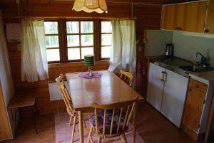 a kitchen with a table and chairs in a cabin at Lidens Stugby in Vaggeryd