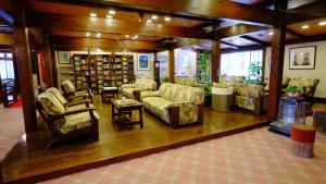 una sala de estar con sofás y sillas en una biblioteca. en Nakadaya, en Takayama