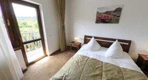 a bedroom with a bed and a large window at Pension Deutsches Haus in Braşov