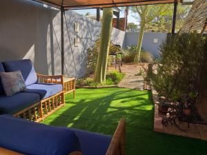 a patio with a lawn with a couch and a chair at Bergsig 2A in Clanwilliam