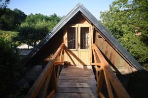a small wooden cabin with a door on a bridge at Robinson Horseville in Karlovac