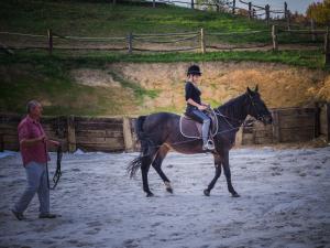 a woman is riding on a horse while a man talks at Robinson Horseville in Karlovac