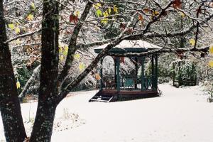a gazebo in the snow under a tree at Merrimeet Cottages in Bright