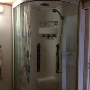 a shower with a glass door in a bathroom at Kaloan in Capesterre-Belle-Eau