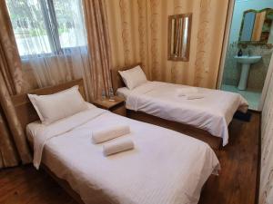 two beds in a hotel room with towels on them at Guesthouse Kurdiani in Mestia in Mestia