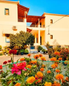 un giardino fiorito di fronte a un edificio di Costa-Rini Hotel a Leonidion (Leonidio)