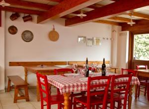 a dining room with a table and red chairs at Agriturismo Ballaminut in Terzo dʼ Aquiléia