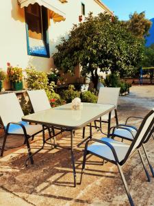 una mesa y cuatro sillas sentadas alrededor de una mesa en Costa-Rini Hotel, en Leonidio