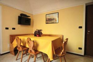 a dining room table with a yellow table cloth and chairs at La Rocca di Efisio in Costigliole dʼAsti