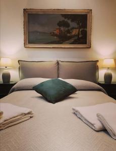 - un lit avec un oreiller vert et une peinture murale dans l'établissement Borgo Pio 51 Apartment Vatican, à Rome