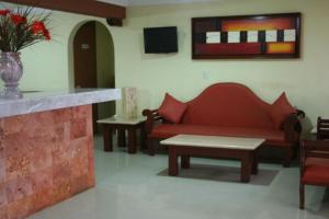 sala de estar con sofá y mesa en Suites Cancun Center en Cancún
